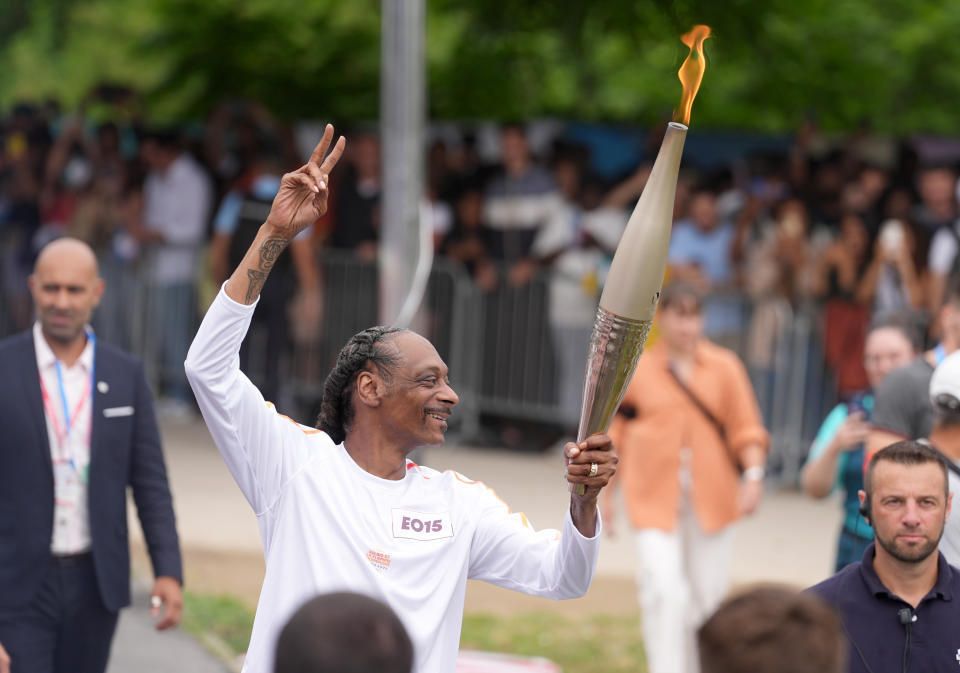 Paris 2024 Olympic Torch Relay. American rapper Snoop Dogg carries the torch in the torch relay. Photo: Marcus Brandt/dpa (Photo by Marcus Brandt/picture alliance via Getty Images)