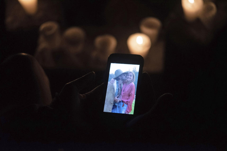 In this Tuesday, March 12, 2019 photo, Francisco Rosales holds his phone with a photo showing him and Catherine Shaw during a memorial for her in San Pedro La Laguna, Guatemala. Shaw, an English tourist whose body was found near a Guatemala highland lake popular with travelers, died of hemorrhaging resulting from a traumatic brain injury, according to an autopsy report completed Tuesday. (AP Photo/Santiago Billy)