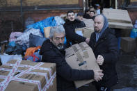 People make a human chain to stack boxes filled with relief supplies at a collection point of the Turkish community in Berlin, Germany, Tuesday, Feb. 7, 2023. Hundreds of members of Berlin's Turkish community flocked to a music school in the German capital to donate essential humanitarian supplies after southern Turkey and northern Syria were hit by double earthquakes on Monday, Feb. 6, 2023. (AP Photo/Markus Schreiber)