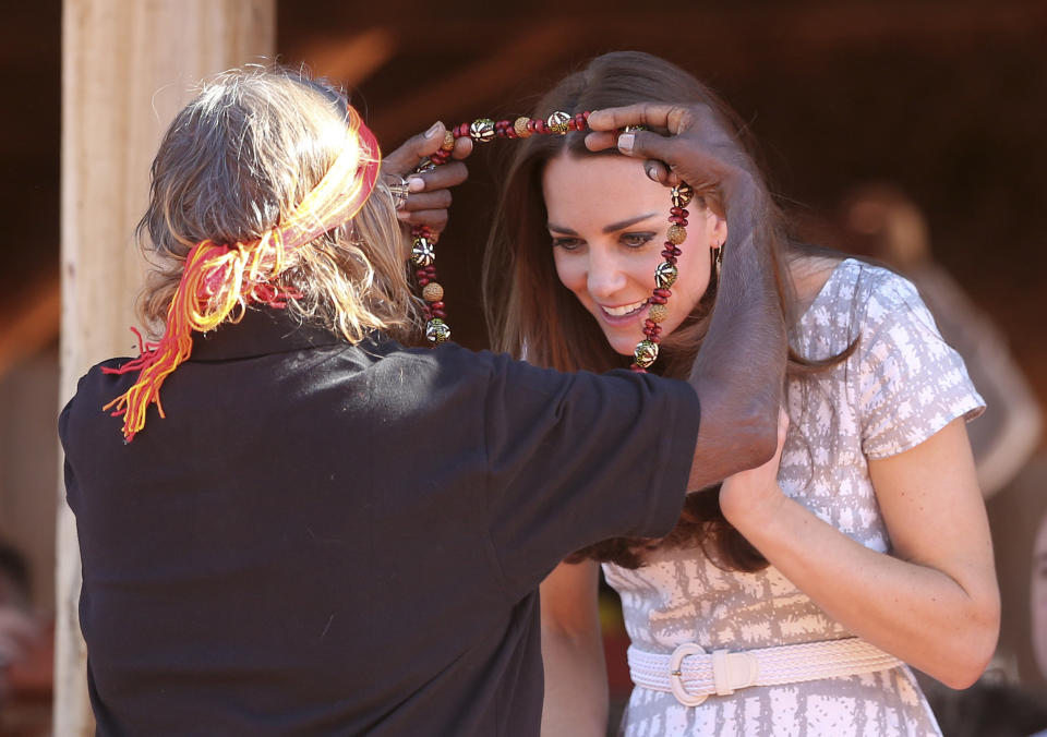 Britain's Kate, the Duchess of Cambridge, receives a necklace from a local aboriginal woman at the Uluru Cultural center at Uluru, Australia, Tuesday, April 22, 2014. (AP Photo/Rob Griffith)