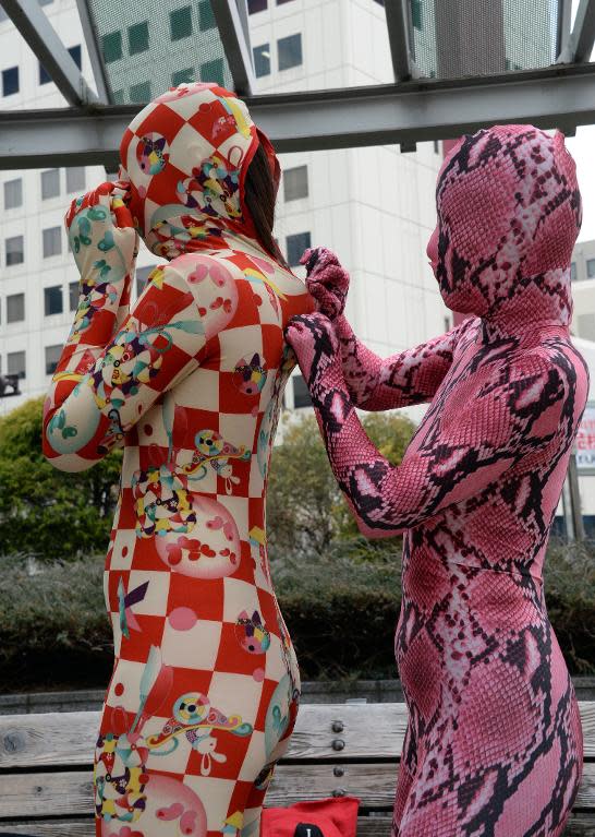 A member of the Tokyo Zentai Club fastens a zipper on a full-body Lycra suit at a park in Tokyo, January 25, 2014