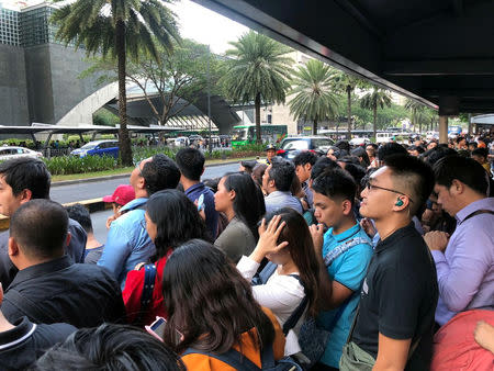 Employees wait outside after being evacuated from the office building after an earthquake in Makati City, Philippines, April 22, 2019. REUTERS/Martin Petty