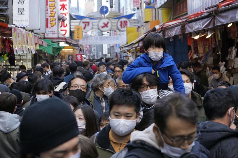People wearing face masks flock to a shopping street famous for a year-end shopping before New Year holidays in Tokyo, Friday, Dec. 30, 2022. Japan on Friday started requiring COVID-19 tests for all passengers arriving from China as an emergency measure against surging infections there and as Japan faces rising case numbers and record-level deaths at home. (AP Photo/Hiro Komae)