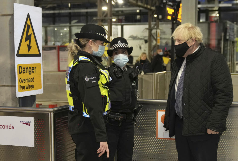 Britain's Prime Minister Boris Johnson meets British Transport Police officers at Liverpool Lime Street station, Liverpool, England, Monday Dec, 6, 2021, ahead of the publication of the government's 10-year drug strategy. (Christopher Furlong/Pool via AP)