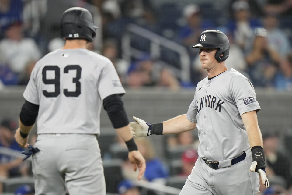 New York Yankees third base DJ LeMahieu, right, and teammate Ben Rice (93) celebrate after scoring on a double by Trent Grisham during fifth-inning baseball game action against the Toronto Blue Jays in Toronto, Sunday, June 30, 2024. (Frank Gunn/The Canadian Press via AP)