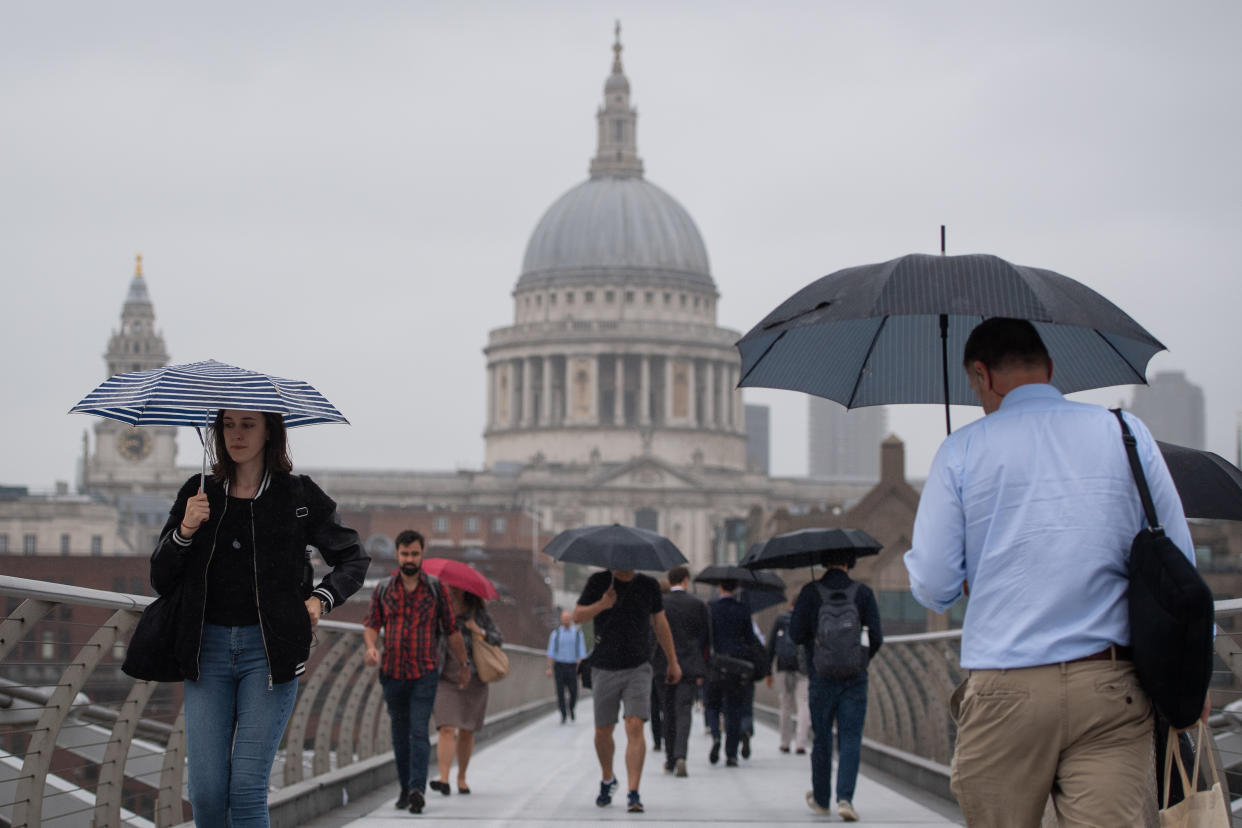 Pedestrians shelter under umbrellas as they cross the Millennium Bridge in central London, during a downpour of rain, as more rainy weather and thunderstorms brought further flood warnings across the UK. Picture date: Monday August 5, 2019. See PA story WEATHER Rain. Photo credit should read: Dominic Lipinski/PA Wire (Photo by Dominic Lipinski/PA Images via Getty Images)