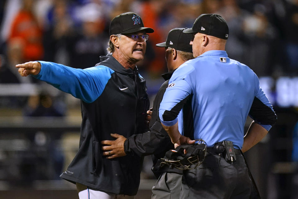 Miami Marlins manager Don Mattingly, left, is restrained by umpire Marvin Hudson, center, as he argues with home plate umpire Ryan Blakney after being ejected during the eighth inning of the team's baseball game against the New York Mets on Tuesday, Sept. 27, 2022, in New York. (AP Photo/Frank Franklin II)