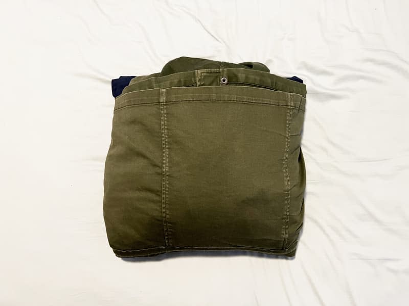 Clothes bundle together with green jacket over top