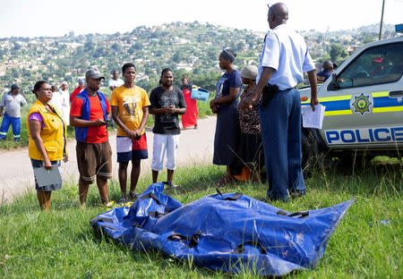 Family members speak to a police officer after one of their family member's body was recovered from under the mud after heavy rains caused by flooding in Mariannhill near Durban, South Africa, April 25, 2019. REUTERS/Rogan Ward