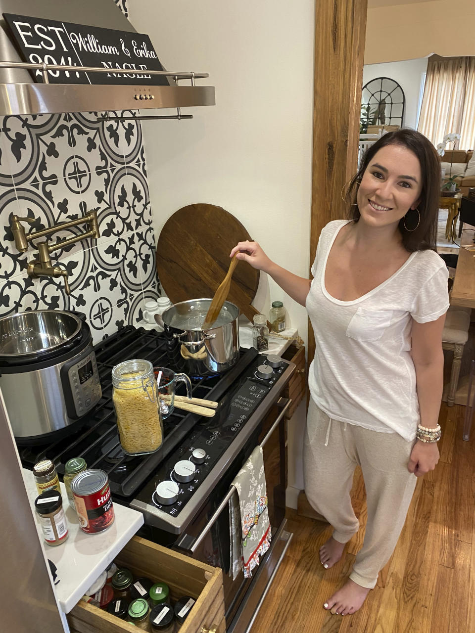 This July 26, 2020 photo shows Erika Navarrete Nagle, a television producer in Denver, Colo., preparing a meal for her family in Denver. Before she began quarantining in late March, the 33-year-old had never cooked chicken. "I was a mess in the kitchen,'' she says. ''I grew up in a Cuban family with a mother and sister who always cooked for me. You'd think I picked up a thing or two, but I've always been a workaholic and I never made time nor had the desire to cook." "It took a global pandemic and mandatory quarantine for me to learn," she says. (William Nagle via AP)