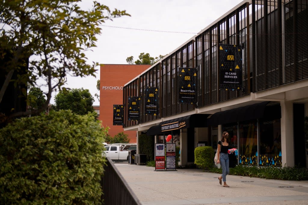 File: A person wears a face mask as they walk past the University Bookstore at the California State University Long Beach (CSULB) campus on 11 August 2021 in Long Beach, California (AFP via Getty Images)