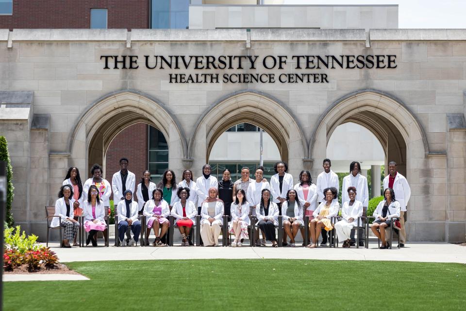 Dr. Christina Rosenthal (middle back) and group of DDS graduates gather for a photo at UT Health Science Center. Students receive their white coats through a ceremony after graduation.