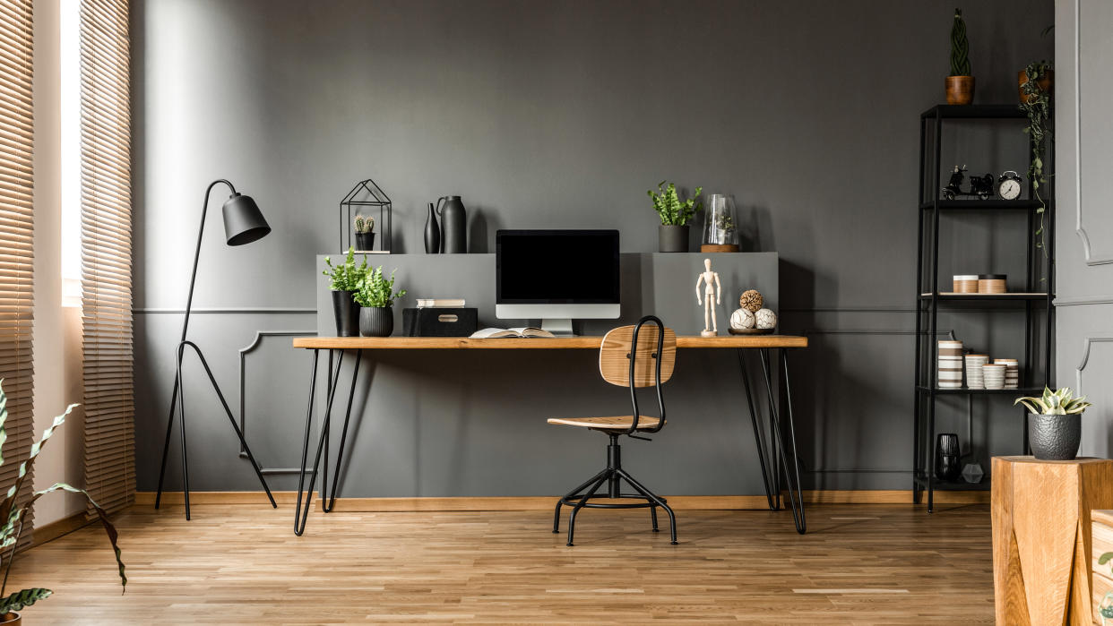  A home office with a standing lamp and bookcase 