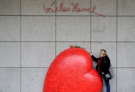 A woman writes a message on a memorial to late Czech Republic's President Vaclav Havel on the occasion of the 80th anniversary of his birth in Prague, Czech Republic October 5, 2016. REUTERS/David W Cerny