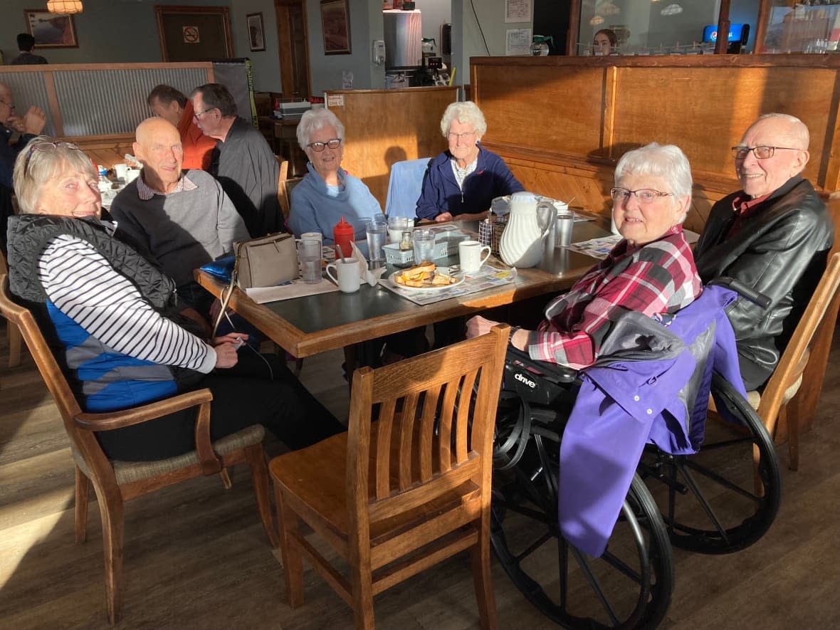 The Garage Gang splits themselves into two tables at breakfast, rotating each meeting so they all get a chance to socialize. (Victoria Walton/CBC - image credit)