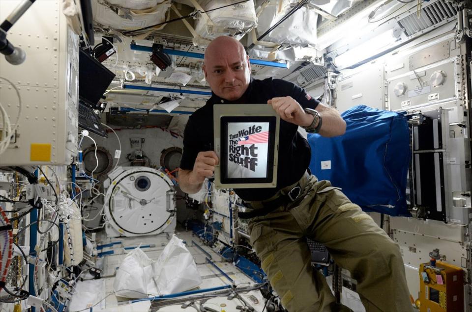 Scott Kelly displays the cover of Tom Wolfe's "The Right Stuff" on his iPad aboard the International Space Station in 2016. <cite>NASA</cite>