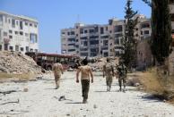 Syrian army soldiers patrol the area around the entrance of Bani Zeid after taking control of the previously rebel-held district of Leramun, on the northwest outskirts of Aleppo, on July 28, 2016