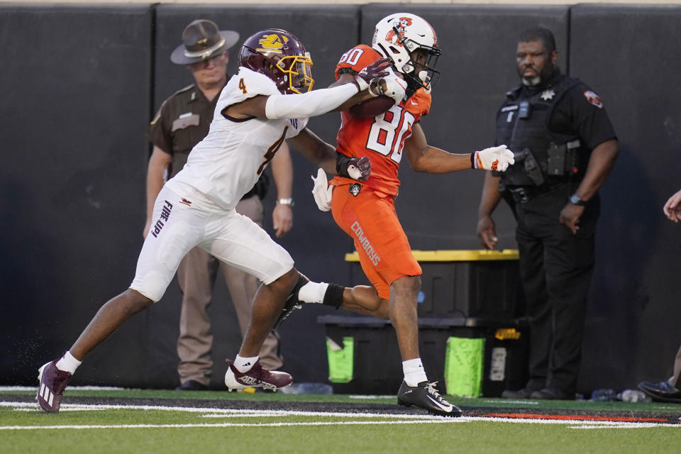 Oklahoma State wide receiver Brennan Presley (80) is pushed out of bounds by Central Michigan defensive back Donte Kent (4) during the first half of an NCAA college football game Thursday, Sept. 1, 2022, in Stillwater, Okla. (AP Photo/Sue Ogrocki)