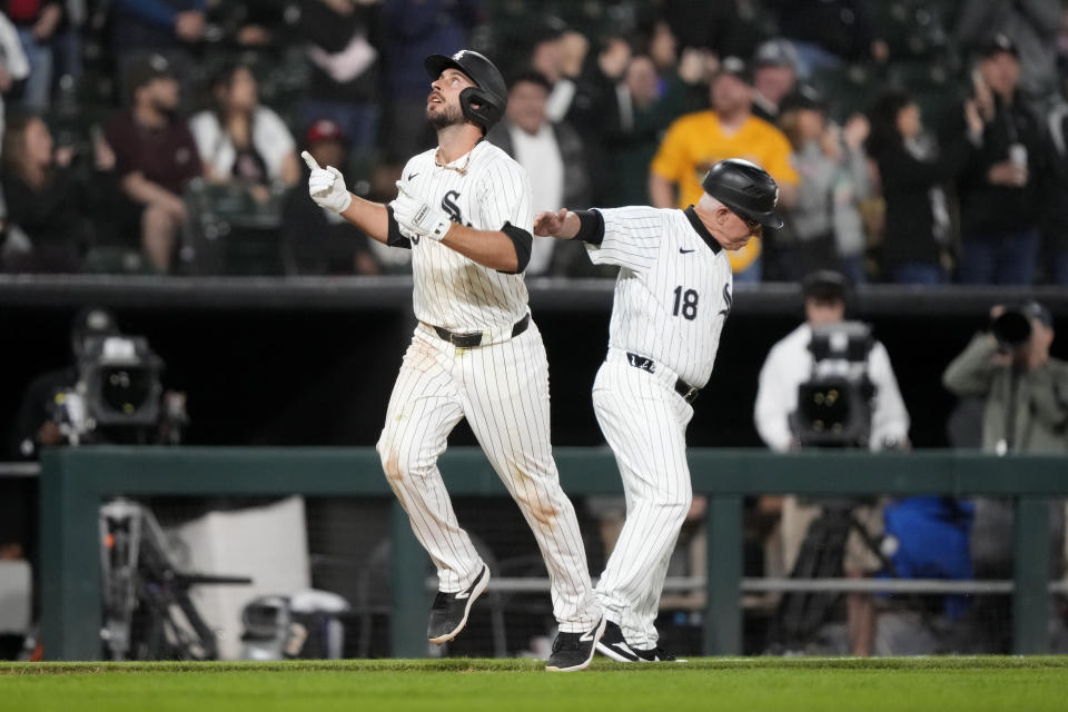 Chicago White Sox's Paul DeJong celebrates his home run off Cleveland Guardians starting pitcher Carlos Carrasco as he passes third base coach Eddie Rodriguez during the seventh inning of a baseball game Friday, May 10, 2024, in Chicago. (AP Photo/Charles Rex Arbogast)