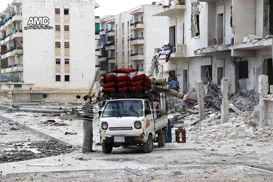 In this photo taken on Sunday Feb. 16, 2014, and provided by the anti-government activist group Aleppo Media Center (AMC), which has been authenticated based on its contents and other AP reporting, Syrian citizens pack their furniture on a mini pickup as they flee their home in Aleppo, Syria. The Western-backed Free Syrian Army has appointed a new military chief, opposition groups announced Monday as they try to restructure a rebel movement that has fallen into disarray as it faces rampant infighting and declining international support for its fight to topple President Bashar Assad. (AP Photo/Aleppo Media Center, AMC)