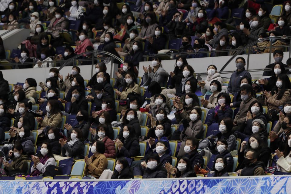 Spectators wearing face masks looks towards an electric board for performance results during a free skating of an ISU Grand Prix of Figure Skating competition in Kadoma near Osaka, Japan, Saturday, Nov. 28, 2020. (AP Photo/Hiro Komae)