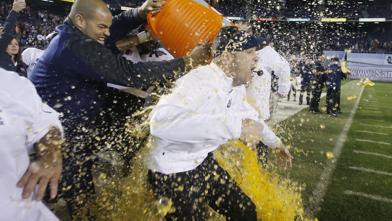 Former Utah State offensive linesman Kevin Whimpey dumps Gatorade on head coach Matt Wells in San Diego Dec. 26, 2013. Whimpey was arrested Tuesday and accused of driving onto the USU football field while impaired. 