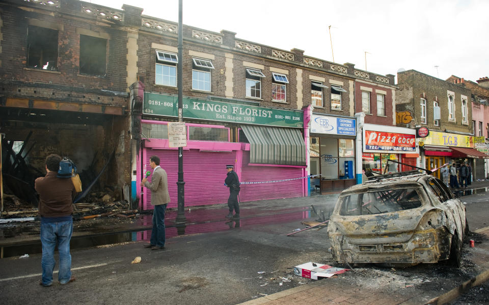 A police officer sets up a cordon around a burnt-out shop on High Road in Tottenham, north London on August 7, 2011. Two police cars and a large number of buildings were on Saturday set ablaze in north London following a protest over the fatal shooting of a 29-year-old man in an armed stand-off with officers. The patrol cars were torched as dozens gathered outside the police station on the High Road in Tottenham.AFP PHOTO/LEON NEAL (Photo credit should read LEON NEAL/AFP via Getty Images)
