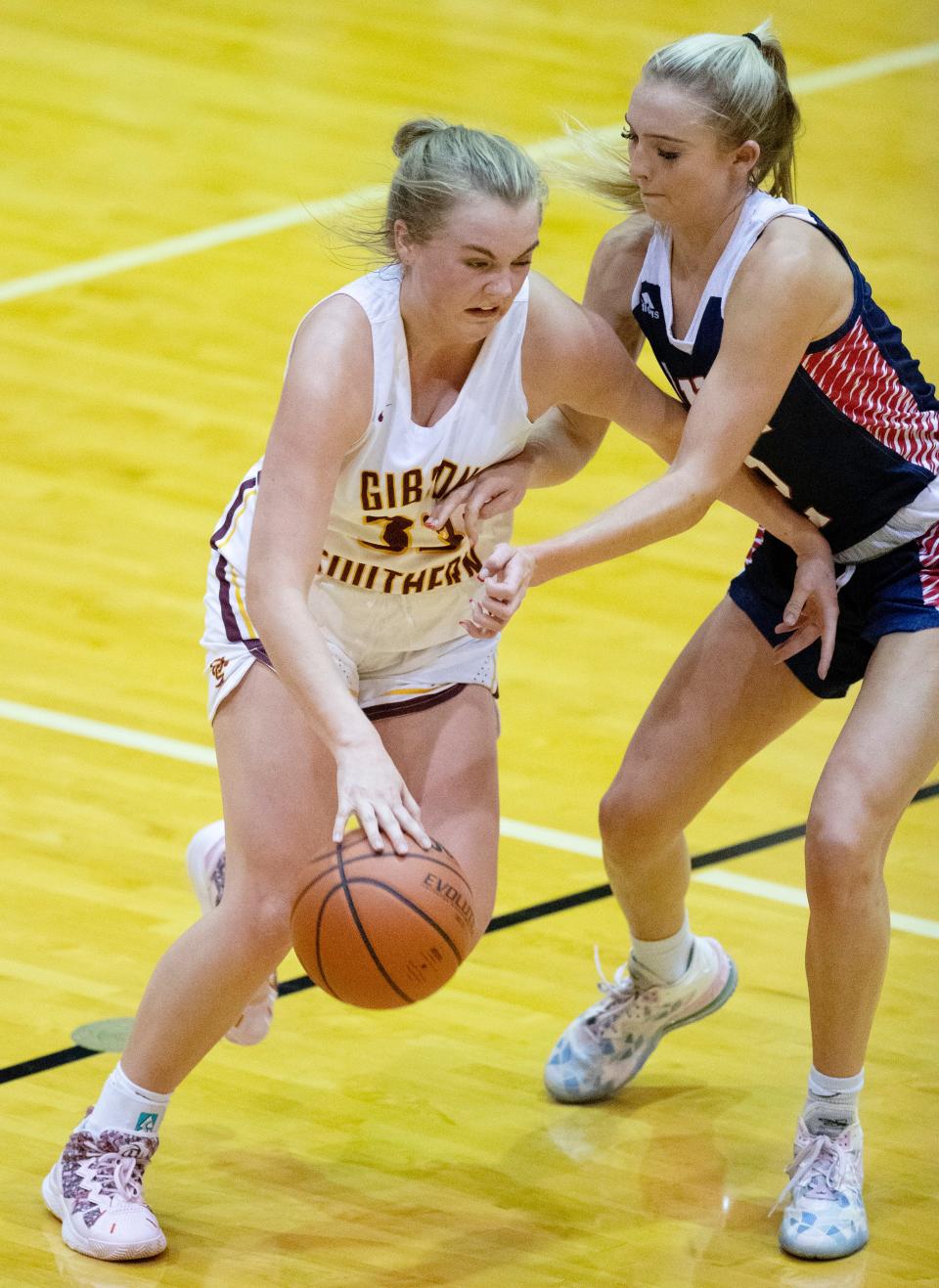 Gibson Southern's Ava Weisheit (33) drives against North Lawrence's Chloe Spreen (2) during the North Basketball Showcase at North High School Friday night, Dec. 2, 2022.