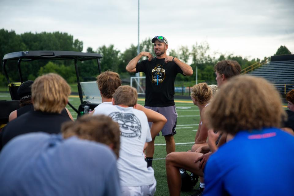 Hamilton head coach Phil Koops talks to his team after their first practice Monday, Aug. 7, 2023, at Hamilton High School.