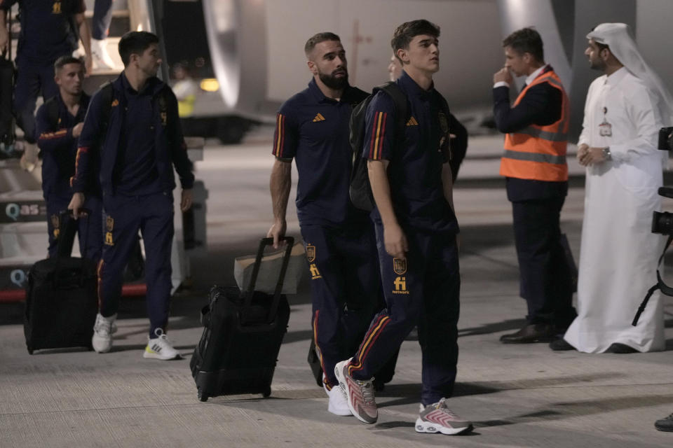 Gave, right, and Dani Carvajal of Spain's national soccer team arrive with teammates at Hamad International airport in Doha, Qatar, Friday, Nov. 18, 2022 ahead of the upcoming World Cup. Spain will play the first match in the World Cup against Costa Rica on Nov. 23. (AP Photo/Hassan Ammar)