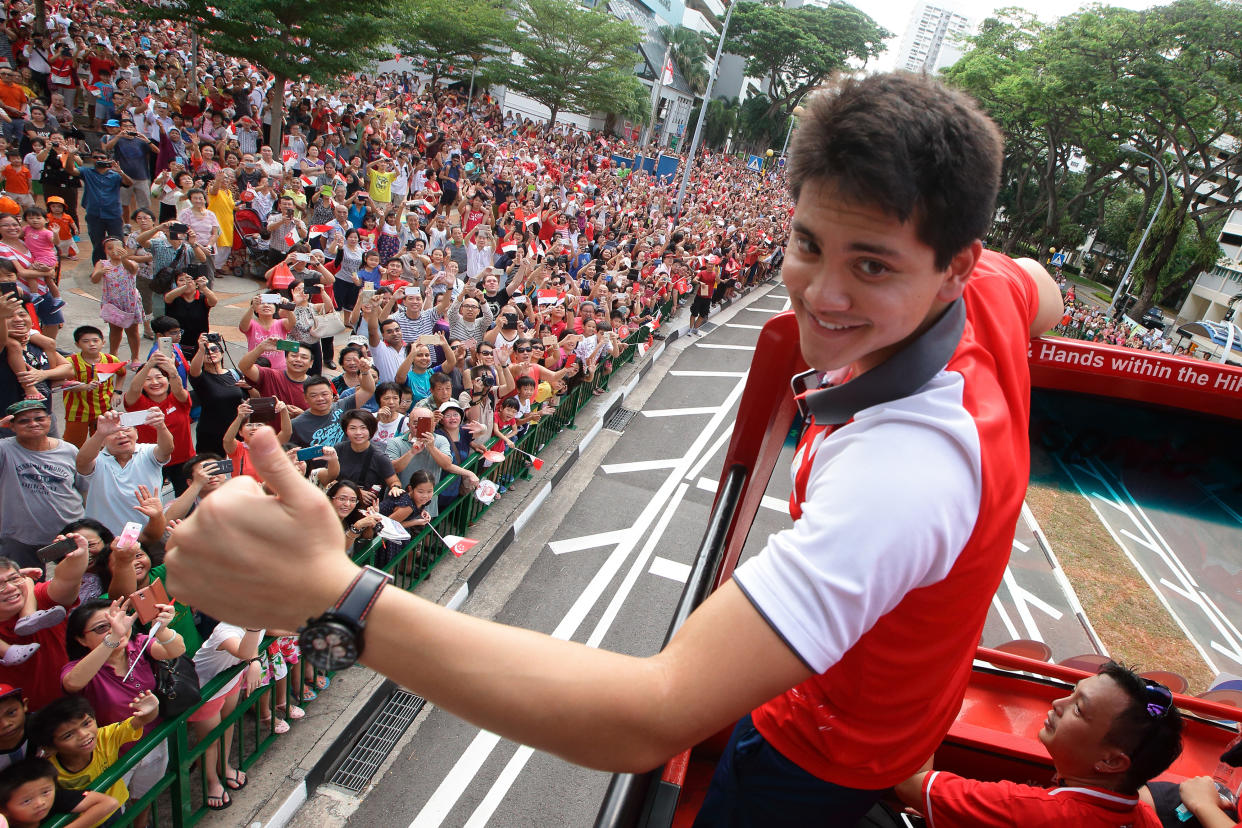 Joseph Schooling gives the thumbs up to Singapore residents during his victory parade after winning an Olympic gold medal at the 2016 Rio de Janeiro Games.