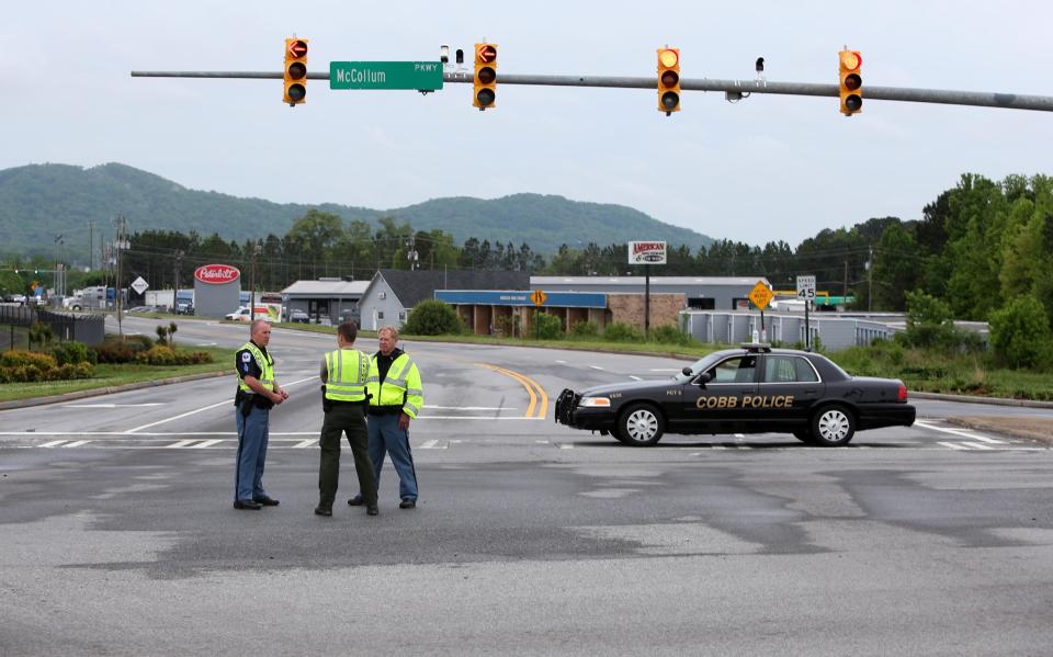 Cobb County Police block off Old US 41 Highway after an early morning workplace shooting at the Airport Road FedEx facility Tuesday April 29, 2014, in Kennesaw, Ga. A shooter opened fire at a FedEx center wounding at least six people before police swarmed the facility. The shooter was found dead from an apparent self-inflicted gunshot wound. (AP Photo/Jason Getz)