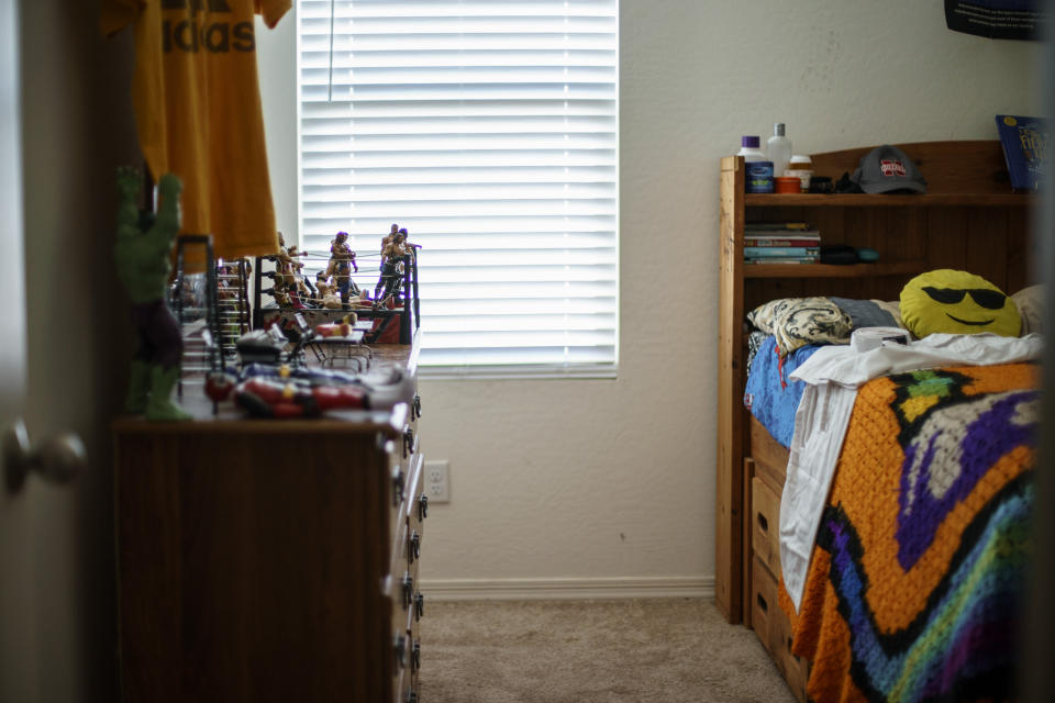 Wrestling action figures sit on a bureau in the bedroom of Donovan James Jones in Buckeye, Ariz., Saturday, March 19, 2022. Jones was born with sickle cell anemia and died at age 13 from complications of COVID-19 on Nov. 12, 2021, as his mother battled the virus herself in the hospital. Teresita Horne didn't get a chance to say goodbye to her only son. "I remember the first time I came in here and I probably screamed the loudest that I've ever screamed in life," says Horne. "I come in here just to kind of sit and sometimes think and it sometimes calms me down. But it also sometimes makes me really sad. And I think that's why I haven't been able to do anything with it because I don't want to get rid of anything or move anything. Just sometimes I just feel like he's going to come in from school, and I just want it to be how he left it." (AP Photo/David Goldman)