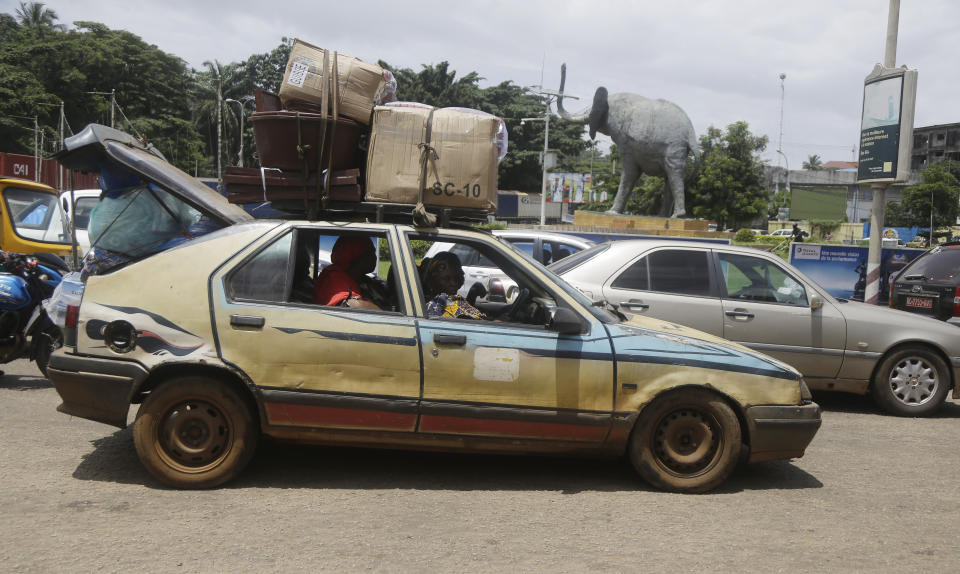 People travel in a taxi in Conakry, Guinea, Thursday, Sept. 9, 2021. Guinea's new military leaders sought to tighten their grip on power after overthrowing President Alpha Conde, warning local officials that refusing to appear at a meeting convened Monday would be considered an act of rebellion against the junta. (AP Photo/Sunday Alamba)