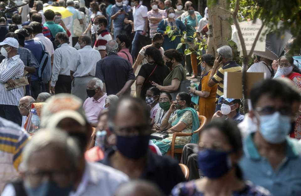 FILE - In this April 26, 2021, file photo, people queue up for COVID-19 vaccine in Mumbai, India. Developing Asian economies will grow at a solid 7.3% pace this year after contracting slightly in 2020 due to the pandemic, the Asian Development Bank says in its latest regional outlook. (AP Photo/Rafiq Maqbool, File)