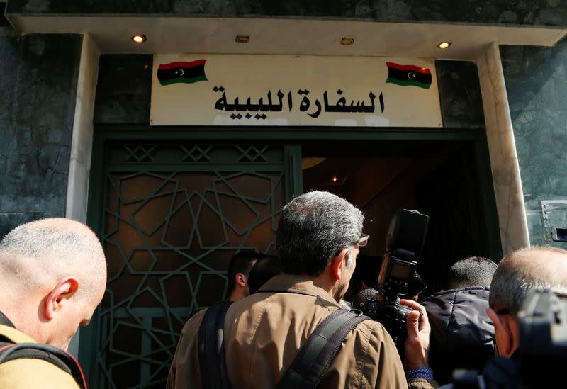 Journalists stand outside the embassy of Libya's eastern-based government led by military commander Khalifa Haftar, that opened in Damascus