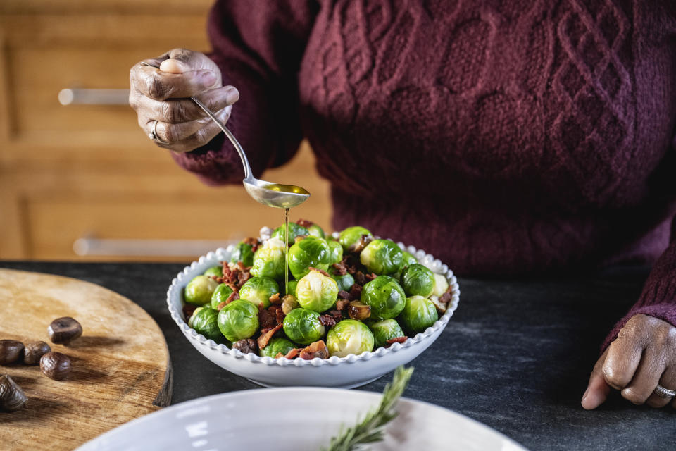 Black female garnishing traditional British Christmas vegetable dish