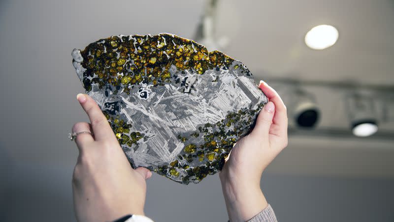 Christie’s auction house sale coordinator Gillian Hawley holds a rock and metal meteorite that was once part of an asteroid in New York on Monday, Feb. 8, 2021. The Maine Mineral & Gem Museum is offering a $25K price to whoever finds a piece of meteorite that landed in Maine.