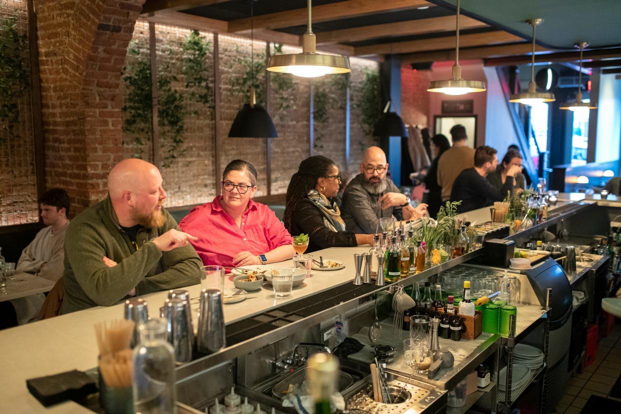 Tom Facer talks to his wife Ruth as Amy Marquardt talks to her husband Eric Amy Marquardt at the first floor bar area at Peridot in Ann Arbor on Friday, March 1, 2024.