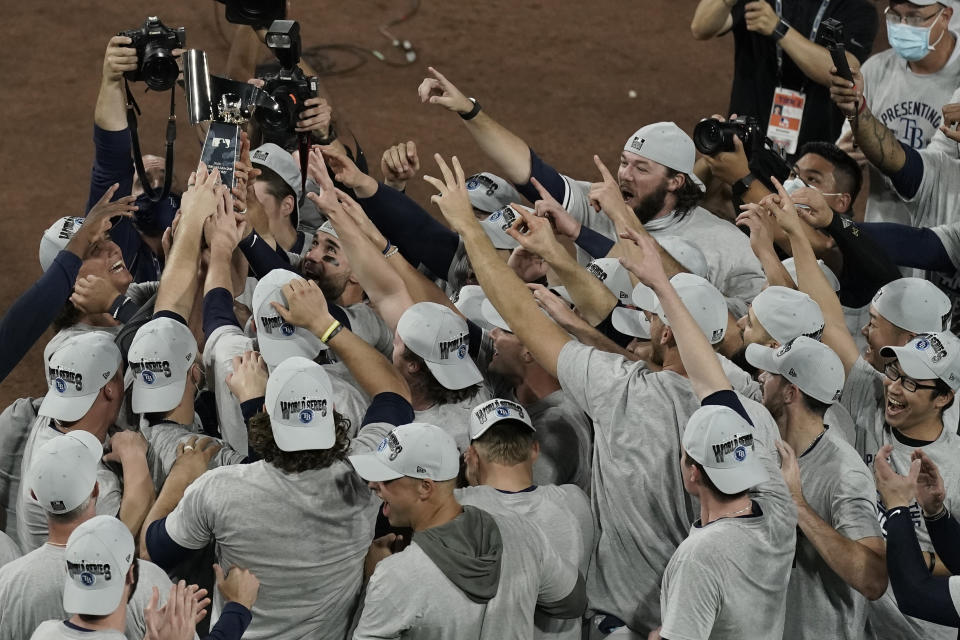 Tampa Bay Rays hold the American League championship trophy following their victory against the Houston Astros in Game 7 of a baseball American League Championship Series, Saturday, Oct. 17, 2020, in San Diego. The Rays defeated the Astros 4-2 to win the series 4-3 games. (AP Photo/Jae C. Hong)