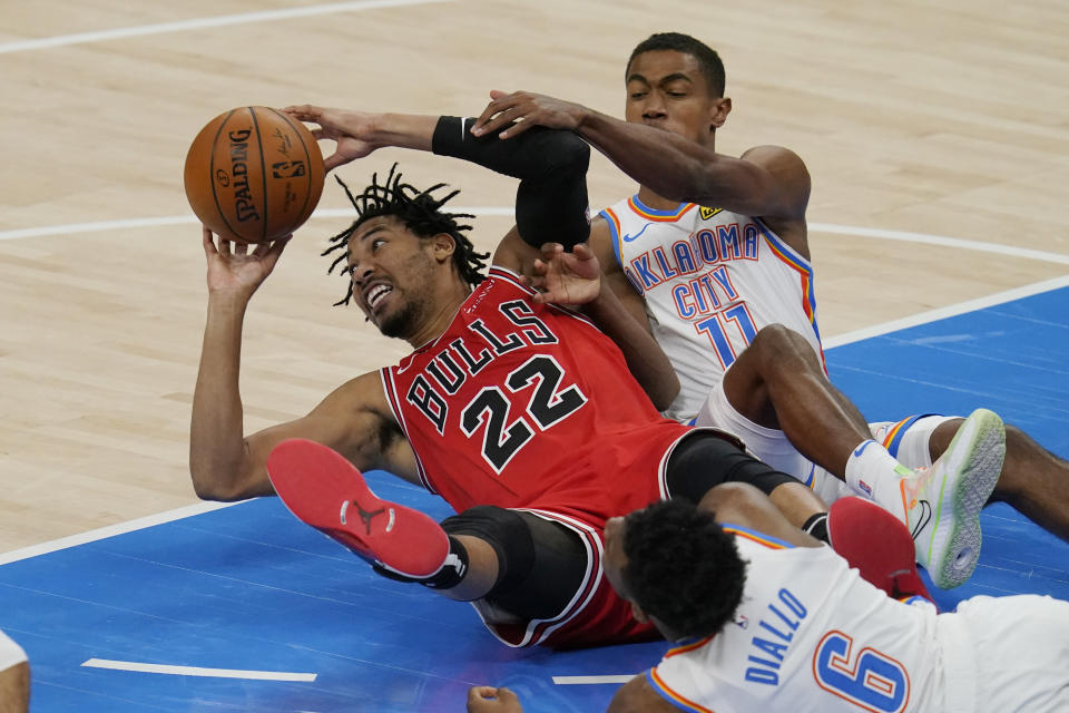 Chicago Bulls forward Otto Porter Jr. (22) passes in front of Oklahoma City Thunder guard Hamidou Diallo (6) and guard Theo Maledon (11) in the second half of a preseason NBA basketball game Wednesday, Dec. 16, 2020, in Oklahoma City. (AP Photo/Sue Ogrocki)