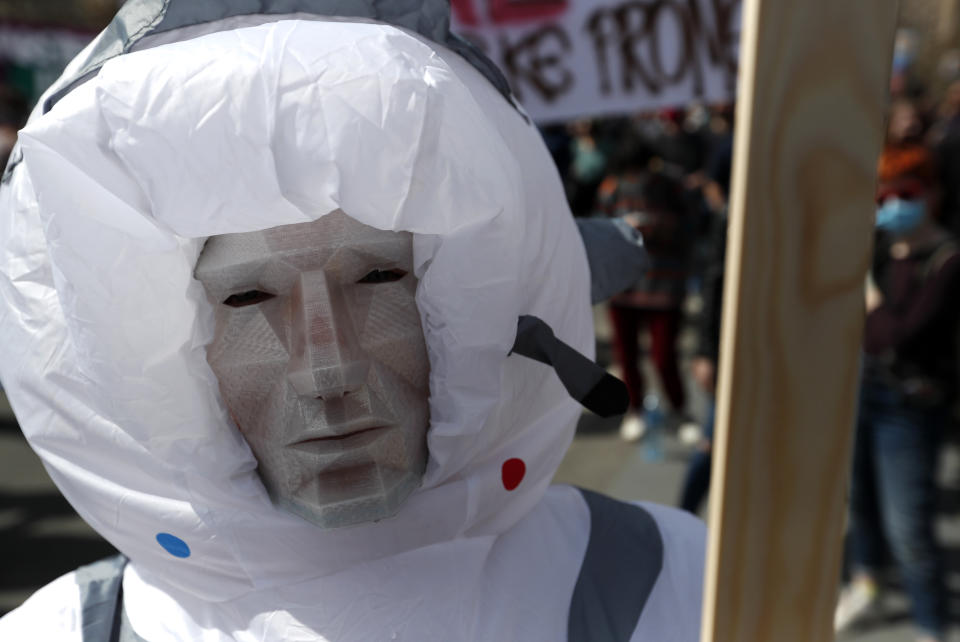 A masked man attends a protest in front of the Serbian Parliament building in Belgrade, Serbia, Saturday, April 10, 2021. Environmental activists are protesting against worsening environmental situation in Serbia. (AP Photo/Darko Vojinovic)