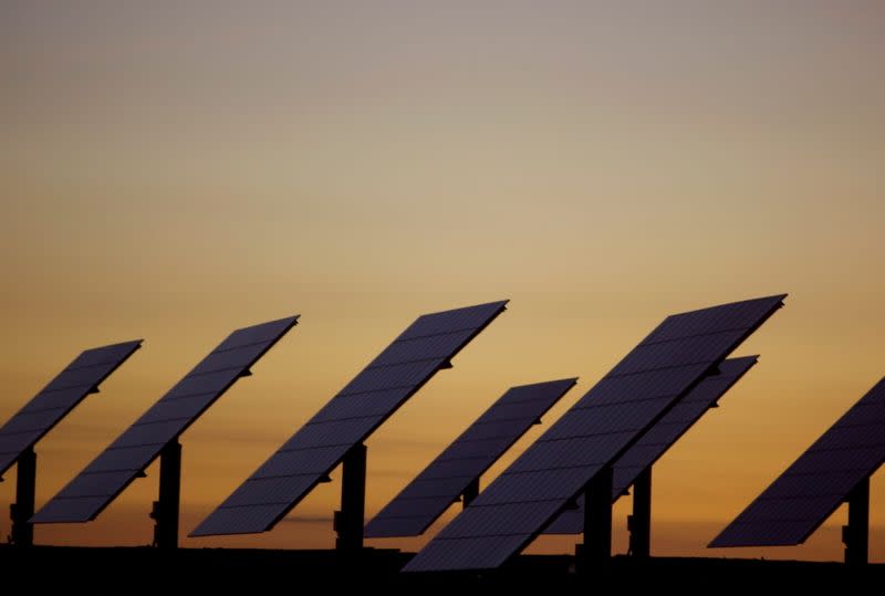 FILE PHOTO: The sun sets beyond solar panels at a power plant in Amareleja