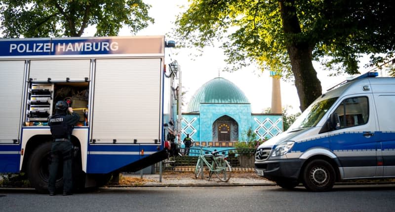 Police officers stand in front of the Islamic Center Hamburg with the Imam Ali Mosque (Blue Mosque) on the Outer Alster during a raid. Daniel Bockwoldt/dpa