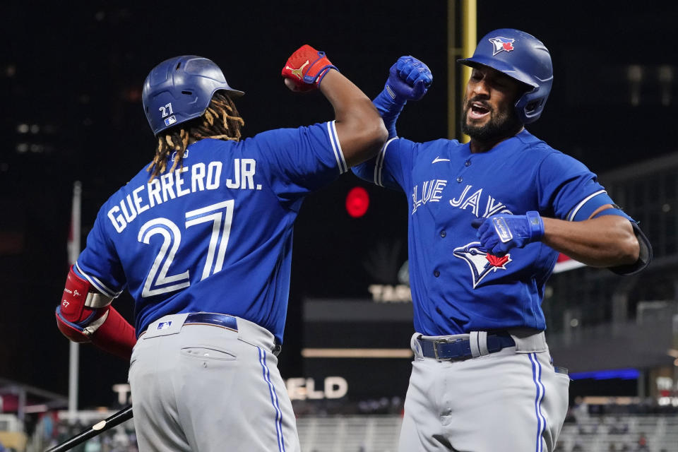 Toronto Blue Jays Marcus Semien, right, celebrates his solo home run off Minnesota Twins pitcher Bailey Ober with Vladimir Guerrero Jr. in the sixth inning of a baseball game, Friday, Sept. 24, 2021, in Minneapolis. (AP Photo/Jim Mone)