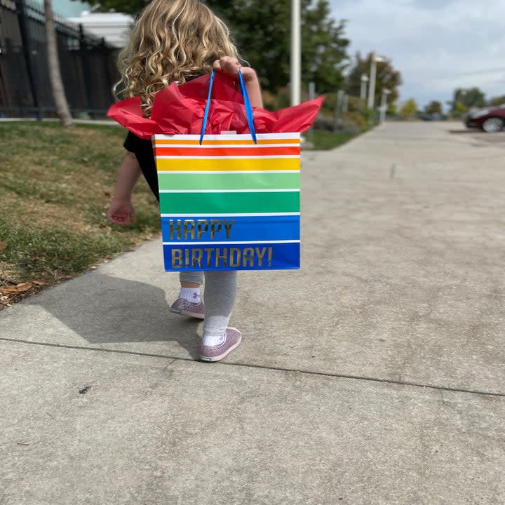 author's daughter walking with a birthday bag