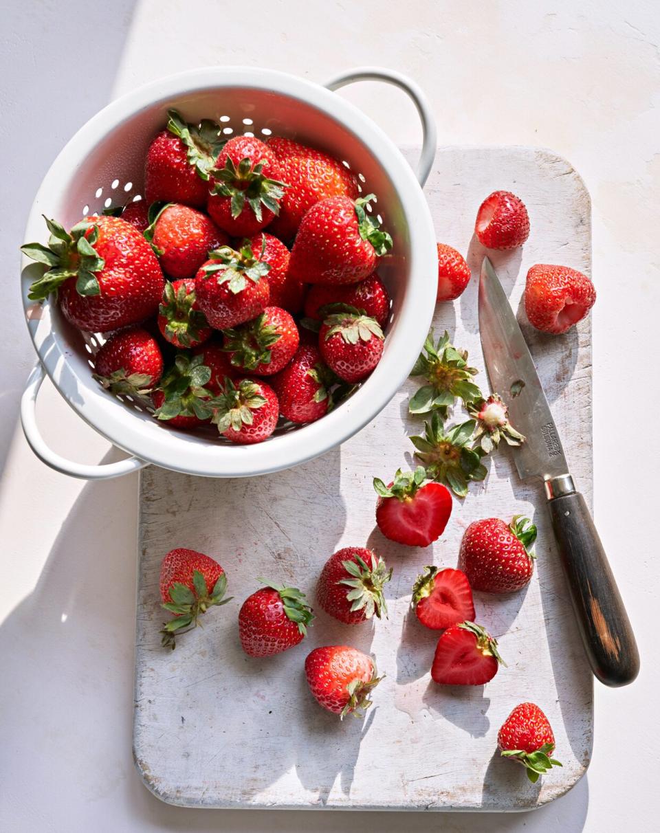 bowl of fresh strawberries on cutting board