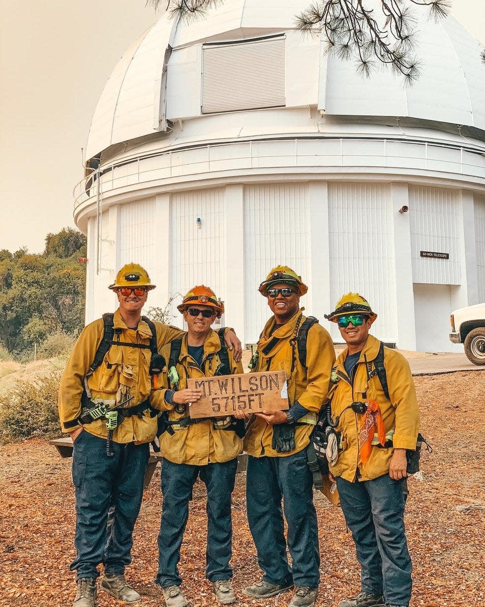 Firefighters from Monrovia, Calif., pose in front of the historic Mount Wilson Observatory after working to protect the 116-year-old structure from the Bobcat Fire.