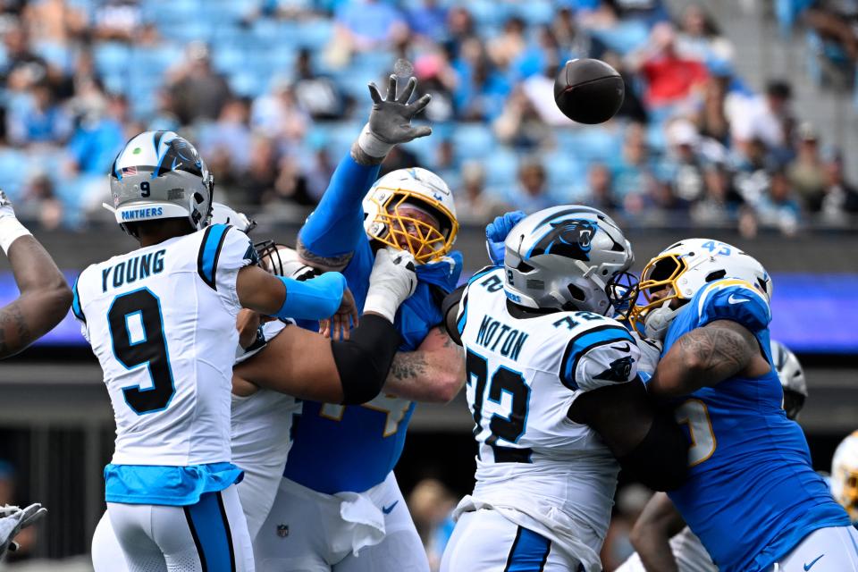 Sep 15, 2024; Charlotte, North Carolina, USA; Carolina Panthers quarterback Bryce Young (9) passes the ball as Los Angeles Chargers defensive tackle Scott Matlock (44) pressures in the fourth quarter at Bank of America Stadium. Mandatory Credit: Bob Donnan-Imagn Images