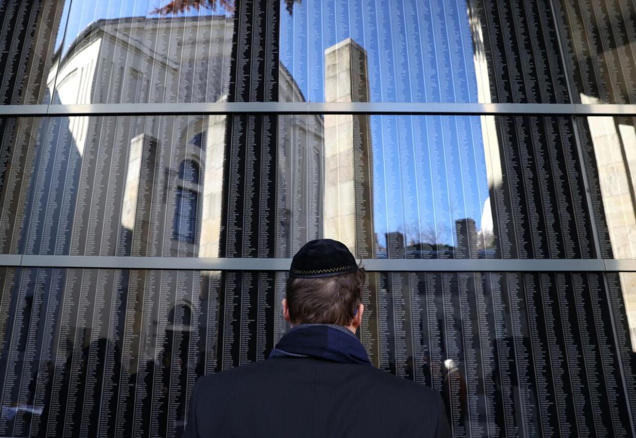 A man is seen at Budapest's Holocaust Memorial Centre on Friday, looking at a wall bearing the names of Holocaust victims. (Bernadett Szabo/Reuters - image credit)